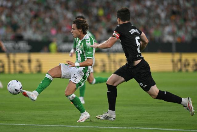 Real Betis' Spanish forward #17 Rodrigo Riquelme vies for the ball with Real Sociedad's Spanish defender #05 Igor Zubeldia (R) during the Spanish league football match between Real Betis and Real Sociedad at the Cartuja stadium in Seville on August 21, 2026. (Photo by JORGE GUERRERO / AFP)