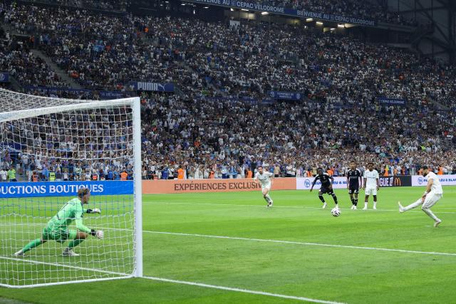 Marseille's Algerian forward #09 Amine Gouiri (R) kicks to score his team's second goal from the penalty spot during the French L1 football match between Olympique de Marseille (OM) and RC Strasbourg Alsace at the Stade Velodrome in Marseille, south-eastern France on August 21, 2026. (Photo by Pascal POCHARD-CASABIANCA / AFP)