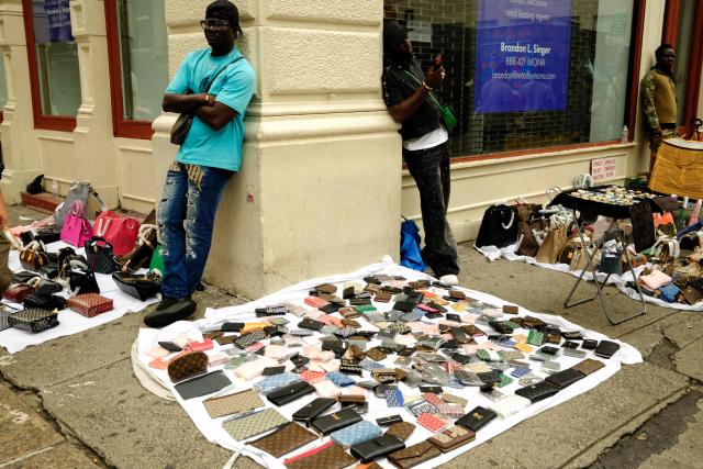 Vendors sell counterfeit luxury goods in the Canal street area of New York City on August 21, 2026. (Photo by CHARLY TRIBALLEAU / AFP)