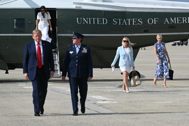 US President Donald Trump (L), White House Press Secretary Karoline Leavitt (2R) and White House Appointments Secretary Natalie Harp (R) walk to board Air Force One at Joint Base Andrews, Maryland on August 21, 2026. Trump is headed to Myrtle Beach, South Carolina to attend a campaign rally for US Senator Darline Graham. (Photo by SAUL LOEB / AFP)