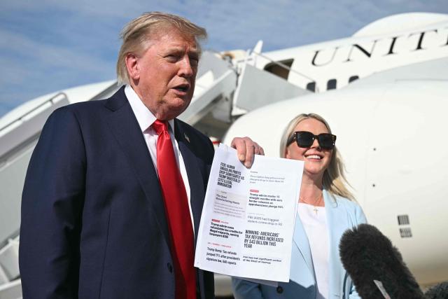 US President Donald Trump, flanked by White House Press Secretary Karoline Leavitt, holds a document as he speaks to reporters before boarding Air Force One at Joint Base Andrews, Maryland on August 21, 2026. Trump is headed to Myrtle Beach, South Carolina to attend a campaign rally for US Senator Darline Graham. (Photo by SAUL LOEB / AFP)