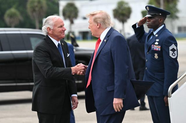 US President Donald Trump shakes hands with South Carolina Governor Henry McMaster after disembarking from Air Force One upon arrival at Myrtle Beach International Airport in Myrtle Beach, South Carolina, on August 21, 2026. Trump is traveling to attend a campaign rally for US Senator Darline Graham. (Photo by SAUL LOEB / AFP)