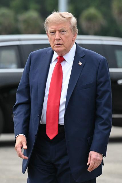 US President Donald Trump looks on after disembarking from Air Force One upon arrival at Myrtle Beach International Airport in Myrtle Beach, South Carolina, on August 21, 2026. Trump is traveling to attend a campaign rally for US Senator Darline Graham. (Photo by SAUL LOEB / AFP)