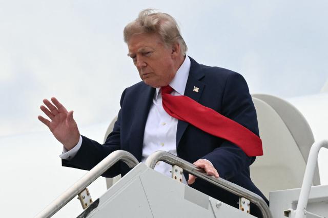 US President Donald Trump waves as he disembarks from Air Force One upon arrival at Myrtle Beach International Airport in Myrtle Beach, South Carolina, on August 21, 2026. Trump is traveling to attend a campaign rally for US Senator Darline Graham. (Photo by SAUL LOEB / AFP)