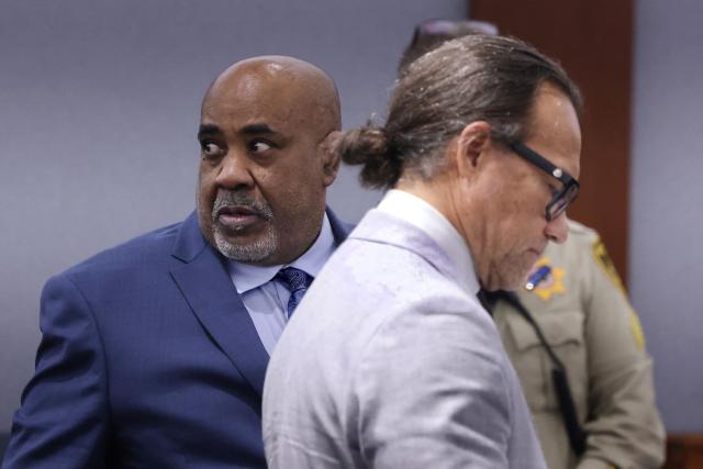 Duane Davis (L) looks around as he appears in court with his attorney Michael Sanft during his murder trial, related to the 1996 killing of rapper Tupac Shakur, at Clark County District Court at the Regional Justice Center in Las Vegas, Nevada, on August 21, 2026. The trial of the former gang leader accused of orchestrating the murder of rapper Tupac Shakur began on August 10, 30 years after one of America's most high-profile unresolved killings. The proceedings, expected to last a month, will likely not make clear who fired the shots that killed the California hip-hop legend on the night of September 7, 1996, while he was in Las Vegas to see a Mike Tyson boxing match. (Photo by Bizuayeha TESFAYE / POOL / AFP)