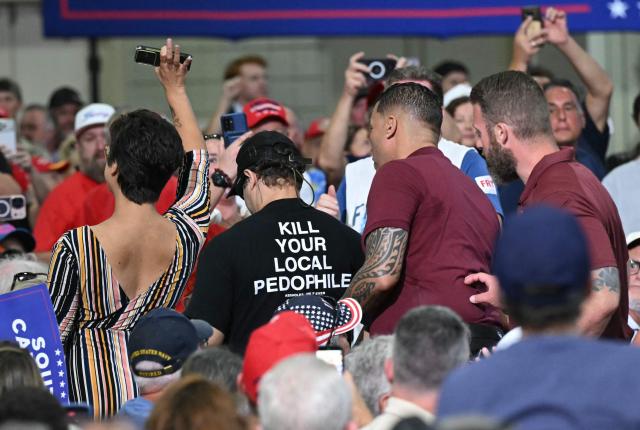 Two protesters, one of them wearing a shirt reading “Kill Your Local Pedophile” are escorted out as US President Donald Trump attends a rally in support of US Senator Darline Graham at the Myrtle Beach Convention Center in Myrtle Beach, South Carolina, on August 21, 2026. (Photo by SAUL LOEB / AFP)