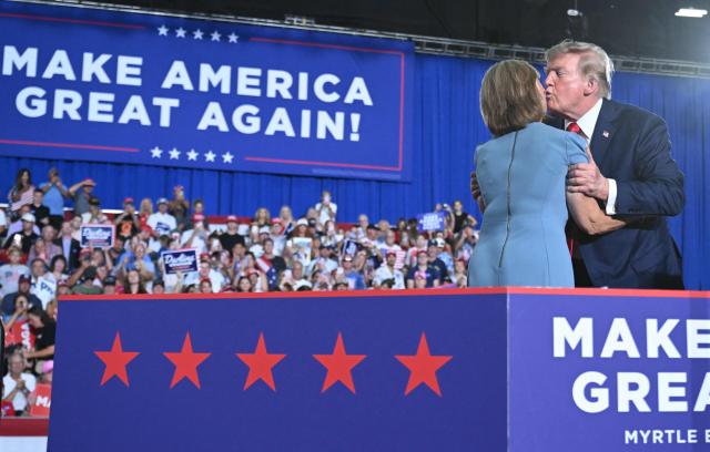 US President Donald Trump welcomes US Senator Darline Graham on stage during a campaign rally at Myrtle Beach Convention Center in Myrtle Beach, South Carolina on August 21, 2026. (Photo by SAUL LOEB / AFP)