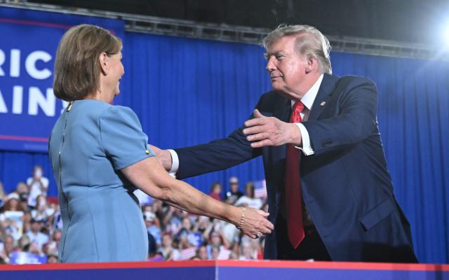 US President Donald Trump welcomes US Senator Darline Graham on stage during a campaign rally at Myrtle Beach Convention Center in Myrtle Beach, South Carolina on August 21, 2026. (Photo by SAUL LOEB / AFP)