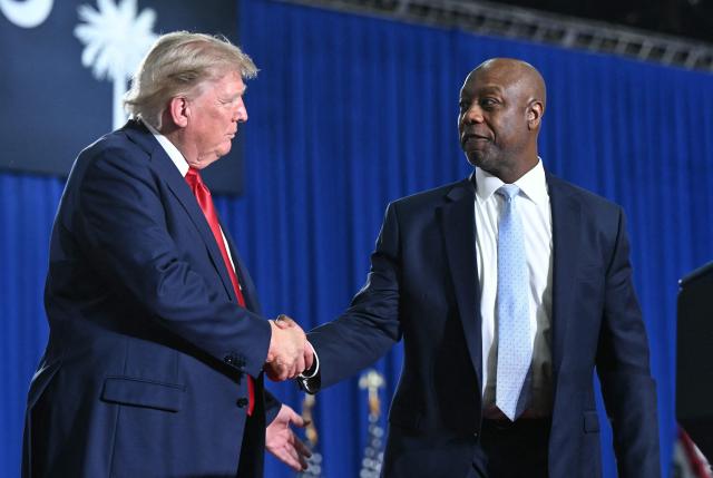US President Donald Trump and US Senator Tim Scott, Republican from South Carolina, shake hands during a campaign rally for US Senator Darline Graham at Myrtle Beach Convention Center in Myrtle Beach, South Carolina on August 21, 2026. (Photo by SAUL LOEB / AFP)