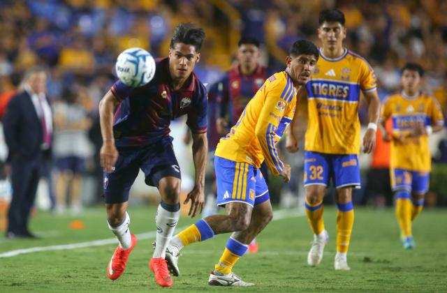 Atlante's forward #09 Luis Puente and Tigres' defender #15 Eduardo Tercero fight for the ball during the Liga MX Apertura football match between Tigres and Atlante at the Universitario stadium in San Nicolas de los Garza, Nuevo Leon, Mexico on August 21, 2026. (Photo by Julio Cesar AGUILAR / AFP)