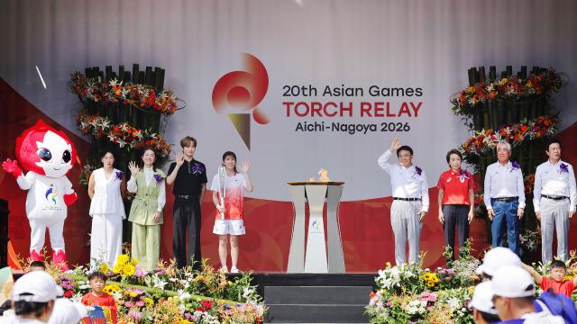 Japanese three-time Olympic wrestling gold medallist Saori Yoshida (C) serves as the first torchbearer in the Aichi–Nagoya Asian Games torch relay in Nagoya city on August 22, 2026 (Photo by JIJI Press / AFP) / Japan OUT