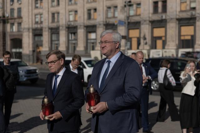 Ukraine's Foreign Affairs Minister Andrii Sybiha (R) and  Germany's Foreign Minister Johann Wadephul observe a nationwide minute of silence to pay tribute to those killed amid the Russian invasion of Ukraine, before laying down lamps as a tribute during a visit of the makeshift memorial for fallen Ukrainian and foreign soldiers on Independence Square in Kyiv on August 22, 2026, amid the Russian invasion of Ukraine. (Photo by Roman PILIPEY / AFP)
