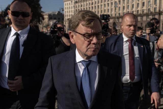 Germany's Foreign Minister Johann Wadephul (C) visits the makeshift memorial for fallen Ukrainian and foreign soldiers on Independence Square in Kyiv on August 22, 2026, amid the Russian invasion of Ukraine. (Photo by Roman PILIPEY / AFP)