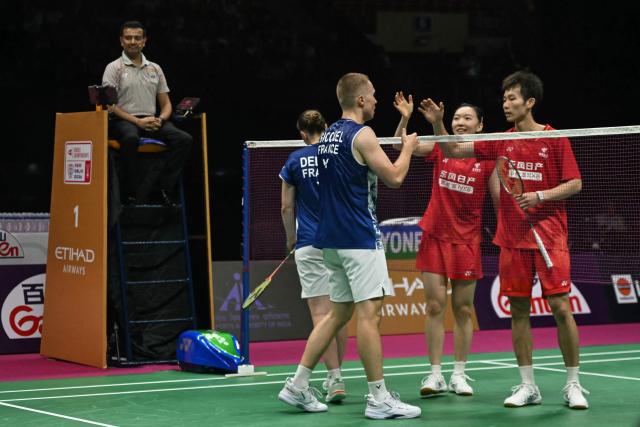 China's Jiang Zhen Bang (R) and Wei Ya Xin (2R) congratulate France's Thom Gicquel (C) and Delphine Delrue for their win during the BWF World Championships mixed doubles semi-final badminton match at the Indira Gandhi Indoor Stadium in New Delhi on August 22, 2026. (Photo by Arun SANKAR / AFP)