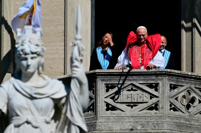 Pope Leo XIV, flanked by San Marino's Captains Regent Alice Mina and Vladimiro Selva, greets the crowd from the balcony of the Public Palace during a pastoral visit to San Marino on August 22, 2026. (Photo by Stefano RELLANDINI / AFP)