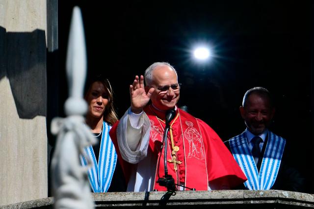 Pope Leo XIV, flanked by San Marino's Captains Regent Alice Mina and Vladimiro Selva, greets the crowd from the balcony of the Public Palace during a pastoral visit to San Marino on August 22, 2026. (Photo by Stefano RELLANDINI / AFP)