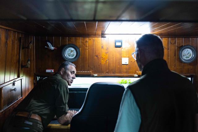 Hunters sit inside a hunting blind overlooking a pond in Saint-Aybert, northern France on August 21, 2026. "A passionate activity" and legal for some, "slaughter" for others: in the Harchies marshes, a Belgian protected natural area, bird conservation organisations are denouncing the opening of the hunting season, authorised for decades just a few kilometres away, on the French side. "Birds have no borders," proclaim several placards carried by a procession of around 700 people that set off at dusk on August 21, 2026 in Bernissart, Belgium, at the call of nine organizations. (Photo by Sameer Al-DOUMY / AFP)