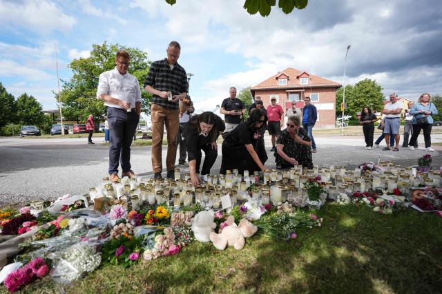 Fagersta residents leave flowers and candles at a makeshift memorial outside a school in Fagersta, central Sweden, on August 22, 2026, a day after a 17-year-old girl was killed and three other people were injured in a sword attack at the school. Police said the suspect was an 18-year-old man who was shot and taken into custody on suspicion of murder. (Photo by Magnus LEJHALL / TT NEWS AGENCY / AFP) / Sweden OUT