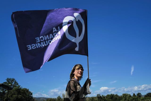 A supporter holds a banner during the 'Amfis' party Summer Conferences 'Universites d'été' (Summer Seminars) of the French left wing party La France Insoumise (LFI) in Châteauneuf-sur-Isère, southeastern France, on August 22, 2026. With more than 8,000 people expected during the weekend, La France Insoumise had never organized summer universities this important. A militant fervor which, combined with Jean-Luc Melenchon's good polls, pushes LFI supporters to believe in victory in the 2027 French presidential election. (Photo by OLIVIER CHASSIGNOLE / AFP)