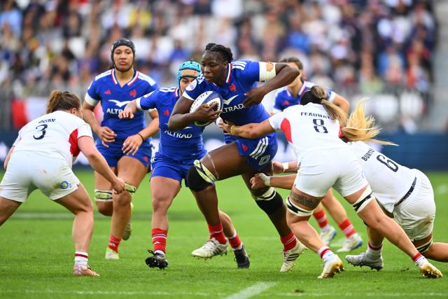 (FILES) France's second row Madoussou Fall Raclot (C) is tackled by England's back row Maddie Feaunati (2R) and England's back row Abi Burton (R) as she runs with the ball during the Women's Six Nations international rugby union match between France and England at the Stade Atlantique in Bordeaux on May 17, 2026. Improving conquest, connections and positions in the scrum, passing on knowledge, creating links... In the Landes, France women's rugby union head coach Francois Ratier gathered front and second rows down to under-18 level for three days for innovative specific work (Photo by GAIZKA IROZ / AFP)