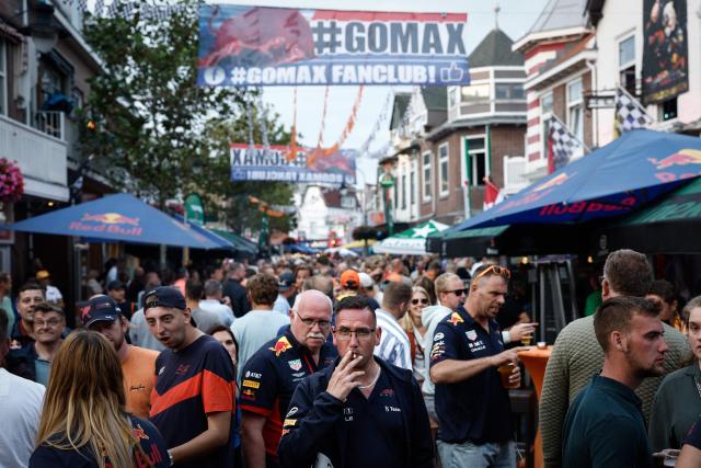 (FILES) F1 fans party in the centre of Zandvoort, after the first day of practice sessions, ahead of the Dutch Formula One Grand Prix, in Zandvoort on August 25, 2023, with banners referencing Red Bull Racing's Dutch driver Max Verstappen. For three days a year, the quiet residential street of Van Speijkstraat in the sleepy Dutch beach resort of Zandvoort transforms itself into a sea of orange streamers and chequered flags, welcoming Formula One fans from around the world. (Photo by Simon Wohlfahrt / AFP)