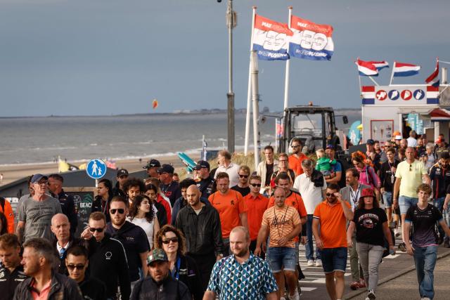 (FILES) F1 fans walk on the shore after the first day of practice sessions, ahead of the Dutch Formula One Grand Prix, in Zandvoort on August 25, 2023. For three days a year, the quiet residential street of Van Speijkstraat in the sleepy Dutch beach resort of Zandvoort transforms itself into a sea of orange streamers and chequered flags, welcoming Formula One fans from around the world. (Photo by Simon Wohlfahrt / AFP)