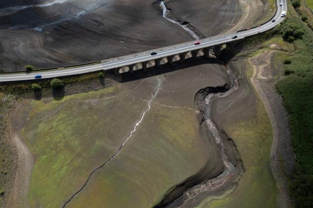 An aerial photograph shows the partially revealed bed of Woodhead Reservoir following a falling water level, near Glossop, northern England on August 22, 2026. Nearly three quarters of England has been classified as in drought after the driest July on record. (Photo by Oli SCARFF / AFP)