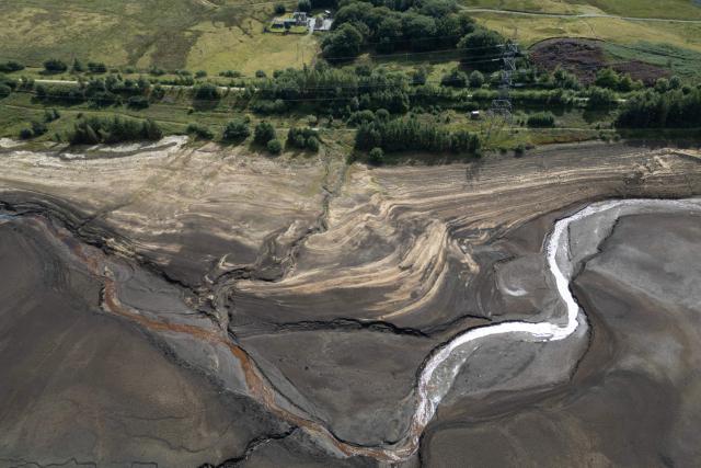 An aerial photograph shows the partially revealed bed of Woodhead Reservoir following a falling water level, near Glossop, northern England on August 22, 2026. Nearly three quarters of England has been classified as in drought after the driest July on record. (Photo by Oli SCARFF / AFP)