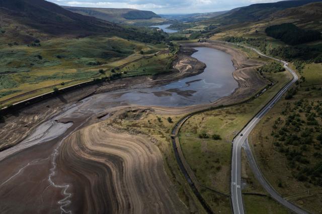 An aerial photograph shows the partially revealed bed of Woodhead Reservoir following a falling water level, near Glossop, northern England on August 22, 2026. Nearly three quarters of England has been classified as in drought after the driest July on record. (Photo by Oli SCARFF / AFP)