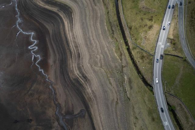 An aerial photograph shows the partially revealed bed of Woodhead Reservoir following a falling water level, near Glossop, northern England on August 22, 2026. Nearly three quarters of England has been classified as in drought after the driest July on record. (Photo by Oli SCARFF / AFP)