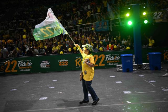 A supporter of Brazil's Senator Flavio Bolsonaro waves a flag during an event for his presidential campaign at the Maracanazinho gymnasium in Rio de Janeiro, Brazil, on August 22, 2026. (Photo by MAURO PIMENTEL / AFP)