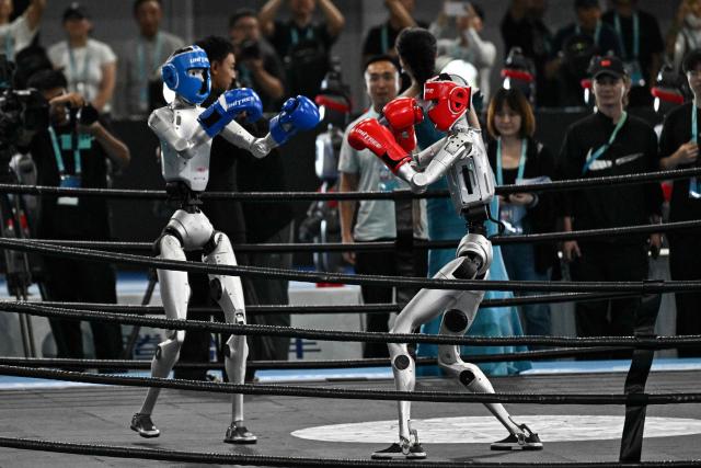 Humanoid robots fight during a kickboxing match at the 2nd World Humanoid Robot Games in Beijing on August 22, 2026. (Photo by Pedro PARDO / AFP)