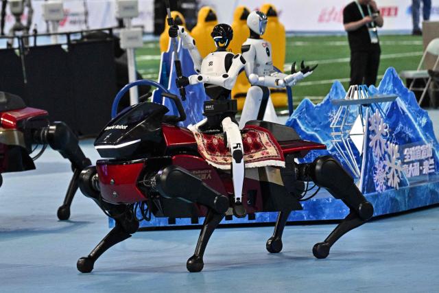 Humanoid robots take part in the opening ceremony of the 2nd World Humanoid Robot Games in Beijing on August 22, 2026. (Photo by Pedro PARDO / AFP)