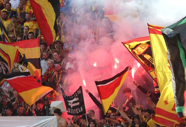 Lens' supporters light flares during the French L1 football match between RC Lens and AJ Auxerre at the Stade Bollaert-Delelis in Lens, northern France on August 22, 2026. (Photo by Francois LO PRESTI / AFP)