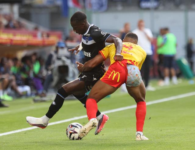 Lens' French defender #14 Matthieu Udol (R) and Auxerre's French defender #29 Marvin Senaya fight for the ball during the French L1 football match between RC Lens and AJ Auxerre at the Stade Bollaert-Delelis in Lens, northern France on August 22, 2026. (Photo by Francois LO PRESTI / AFP)