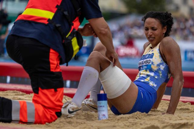Germany's Malaika Mihambo grimaces in pain as she recives medical assistance during the women's long jump event of the Silesia Diamond League athletics meeting in Katowice, Poland, on August 22, 2026. (Photo by Wojtek RADWANSKI / AFP)