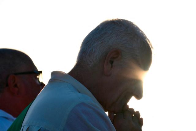 A priest prays as Pope Leo XIV leads a mass in the port of Rimini during a pastoral visit on August 22, 2026. (Photo by Stefano RELLANDINI / AFP)