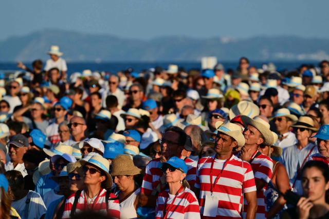 Faithful attend a holy mass in the port of Rimini during a pastoral visit of Pope Leo XIV on August 22, 2026. (Photo by Stefano RELLANDINI / AFP)