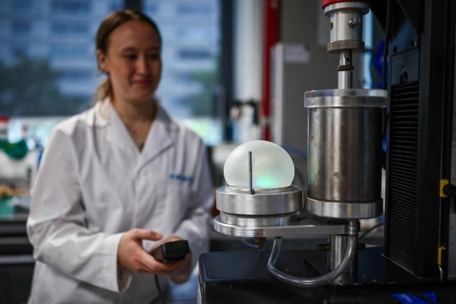 Co-inventor of Bioloon and PhD researcher Juliana Cumming gives a demonstration of a piece of fully biodegradable rubber being inflated, at Imperial College in London on August 19, 2026. A symbol of celebration but an ecological nightmare, the party balloon is undergoing a green revolution: researchers in London claim to have developed the first fully biodegradable model, which they plan to bring to market within two years. (Photo by HENRY NICHOLLS / AFP) / TO GO WITH STORY by Alexandra DEL PERAL