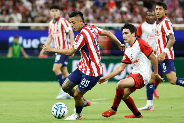 Guadalajara's forward #25 Roberto Alvarado controls the ball past Tijuana's midfielder #10 Gilberto Mora during the Liga MX Apertura football match between Guadalajara and Tijuana at the Akron stadium in Zapopan, Jalisco, Mexico on August 22, 2026. (Photo by ULISES RUIZ / AFP)