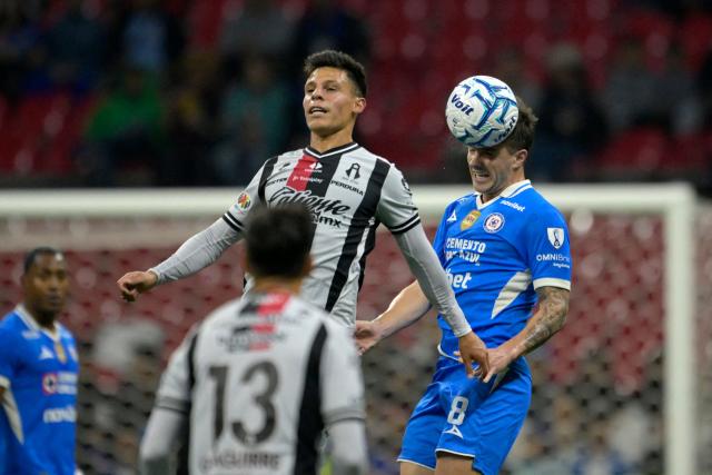Cruz Azul's Argentine midfielder #08 Agustin Palavecino (R) heads the ball past Atlas' forward #58 Arturo Gonzalez during the Liga MX Apertura football match between Guadalajara and Tijuana at the Akron stadium in Zapopan, Jalisco, Mexico on August 22, 2026. (Photo by Alfredo ESTRELLA / AFP)