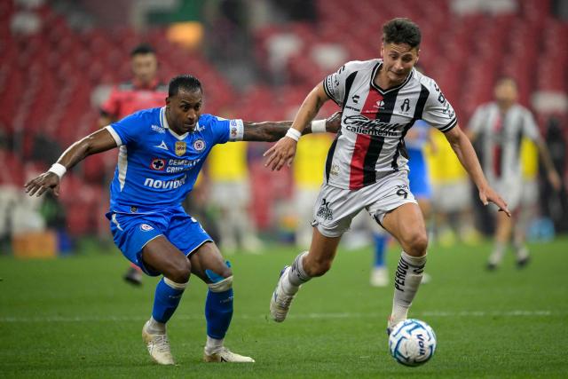Cruz Azul's Colombian defender #04 Willer Ditta (L) and Atlas' Argentine forward #09 Florian Monzon (R) fight for the ball during the Liga MX Apertura football match between Cruz Azul and Atlas at the Ciudad de los Deportes Stadium in Mexico City on August 22, 2026. (Photo by Alfredo ESTRELLA / AFP)
