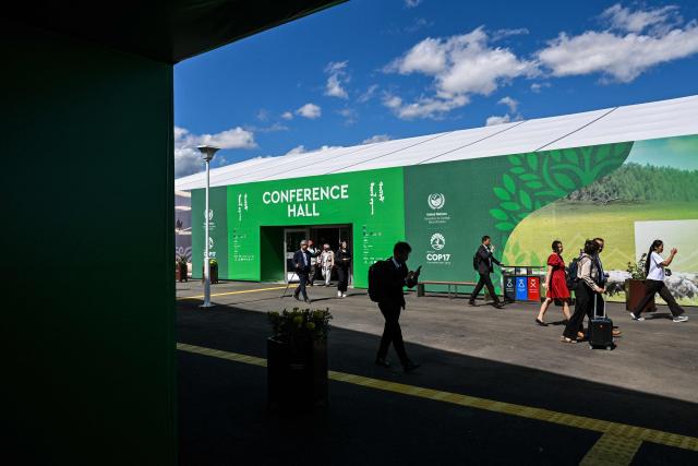 People walk outside the conference hall ahead of the 17th Session of the Conference of the Parties (COP17) of the United Nations Convention to Combat Desertification (UNCCD) at the venue in Ulaanbaatar on August 23, 2026. (Photo by Hector RETAMAL / AFP)