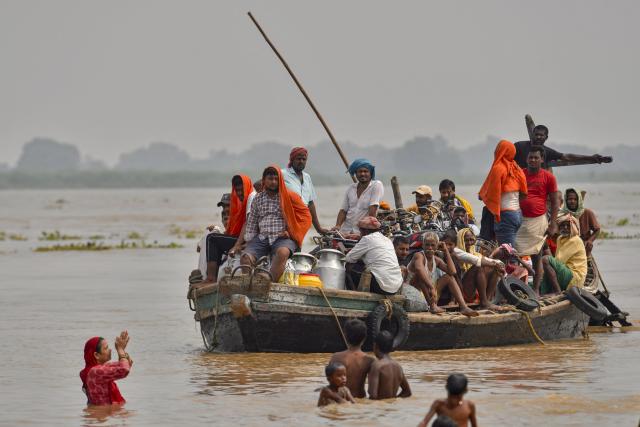Flood-affected residents along with their belongings move to a safer place by boat as the water level of the Ganges rises following heavy rains in Patna on August 23, 2026. (Photo by Sachin KUMAR / AFP)
