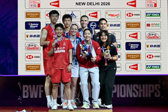 Gold medalists France's Thom Gicquel (3R) and Delphine Delrue (4L), silver medalists China's Feng Yan Zhe (L) and Huang Dong Ping (2L) pose on the podium alongside bronze medalists China's Jiang Zhen Bang (3L) and Wei Ya Xin (3R) and Indonesia's Nita Violina Marwah (R) and Amri Syahnawi during an awards ceremony at the end of the BWF World Championships mixed doubles final badminton match in the Indira Gandhi Indoor Stadium of New Delhi on August 23, 2026. (Photo by Sajjad HUSSAIN / AFP)
