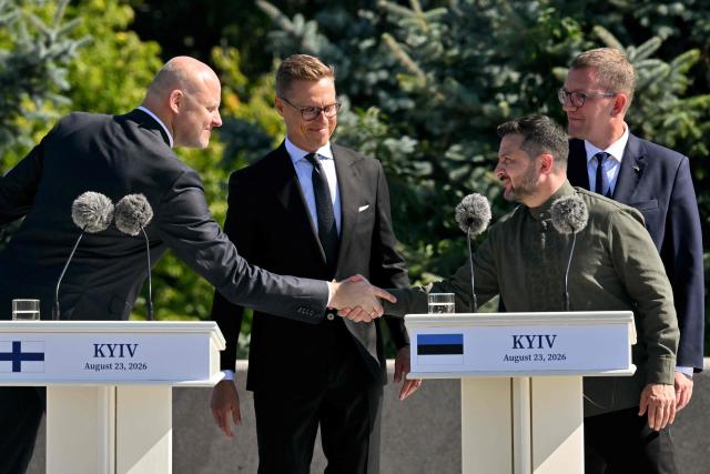 Latvia's Prime Minister Andris Kulbergs (L) shakes hands with Ukrainian President Volodymyr Zelensky (2nd-R) as Finland's President Alexander Stubb (C) and Estonia's Prime Minister Kristen Michal (R) looks on as they attend a ceremony marking the National Flag Day of Ukraine in Kyiv on August 23, 2026, amid Russian invaion of Ukraine. (Photo by Sergei SUPINSKY / AFP)