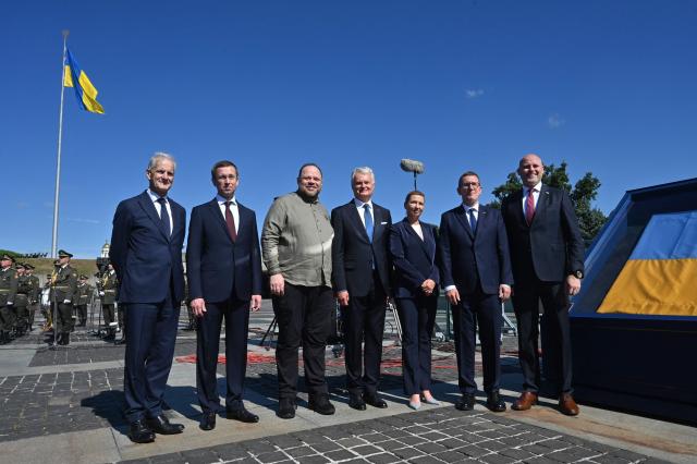 (L-R )Norway's Prime Minister Jonas Gahr Store, Finland's President Alexander Stubb,   Speaker (Chairman) of the Ukrainian Parliament Verkhovna Rada, Ruslan Stefanchuk, Lithuania's President Gitanas Nauseda, Denmark's Prime Minister Mette Frederiksen,  Estonia's Prime Minister Kristen Michal and Latvia's Prime Minister Andris Kulbergs pose next to the first official  flag of Ukraine during a ceremony marking the National Flag Day of Ukraine in Kyiv on August 23, 2026, amid Russian invaion of Ukraine. (Photo by Sergei SUPINSKY / AFP)