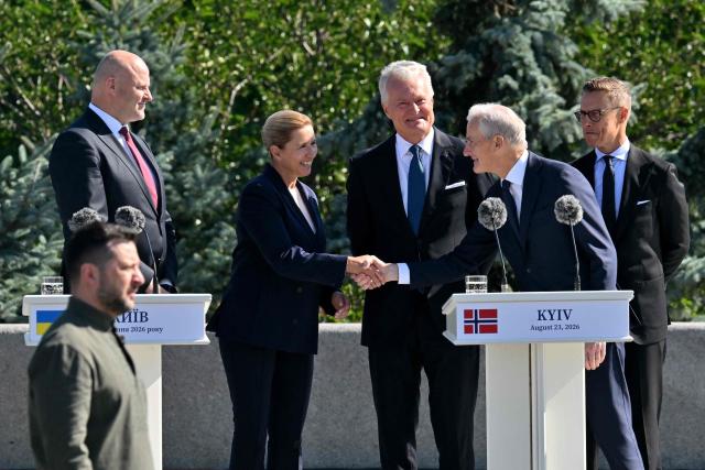 Denmark's Prime Minister Mette Frederiksen (2ndL) shakes hands with Norway's Prime Minister Jonas Gahr Store (2nd-R) as Latvia's Prime Minister Andris Kulbergs (L), Lithuania's President Gitana Nauseda (C), Finland's President Alexander Stubb (R) and Ukraine's President Volodymyr Zelensky (L- below)look on during a ceremony marking the National Flag Day of Ukraine in Kyiv on August 23, 2026, amid Russian invaion of Ukraine. (Photo by Sergei SUPINSKY / AFP)