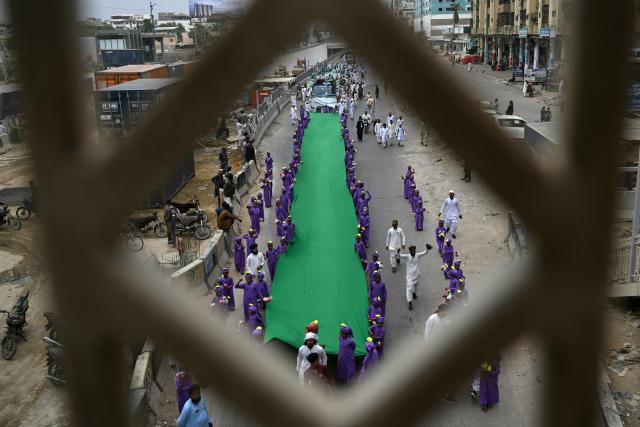 Sunni Muslim students from an Islamic seminary holding a religious flag participate in a rally ahead of Eid-e-Milad-un-Nabi, which commemorates the birth anniversary of Prophet Muhammad, in Karachi on August 23, 2026. (Photo by Rizwan TABASSUM / AFP)