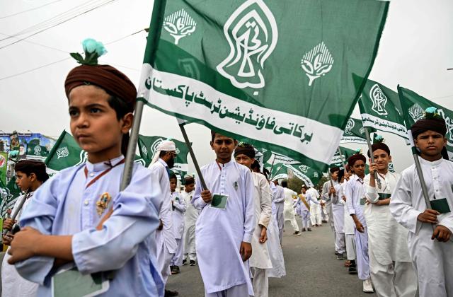 Sunni Muslim students from an Islamic seminary holding religious flags participate in a rally ahead of Eid-e-Milad-un-Nabi, which commemorates the birth anniversary of Prophet Muhammad, in Karachi on August 23, 2026. (Photo by Rizwan TABASSUM / AFP)